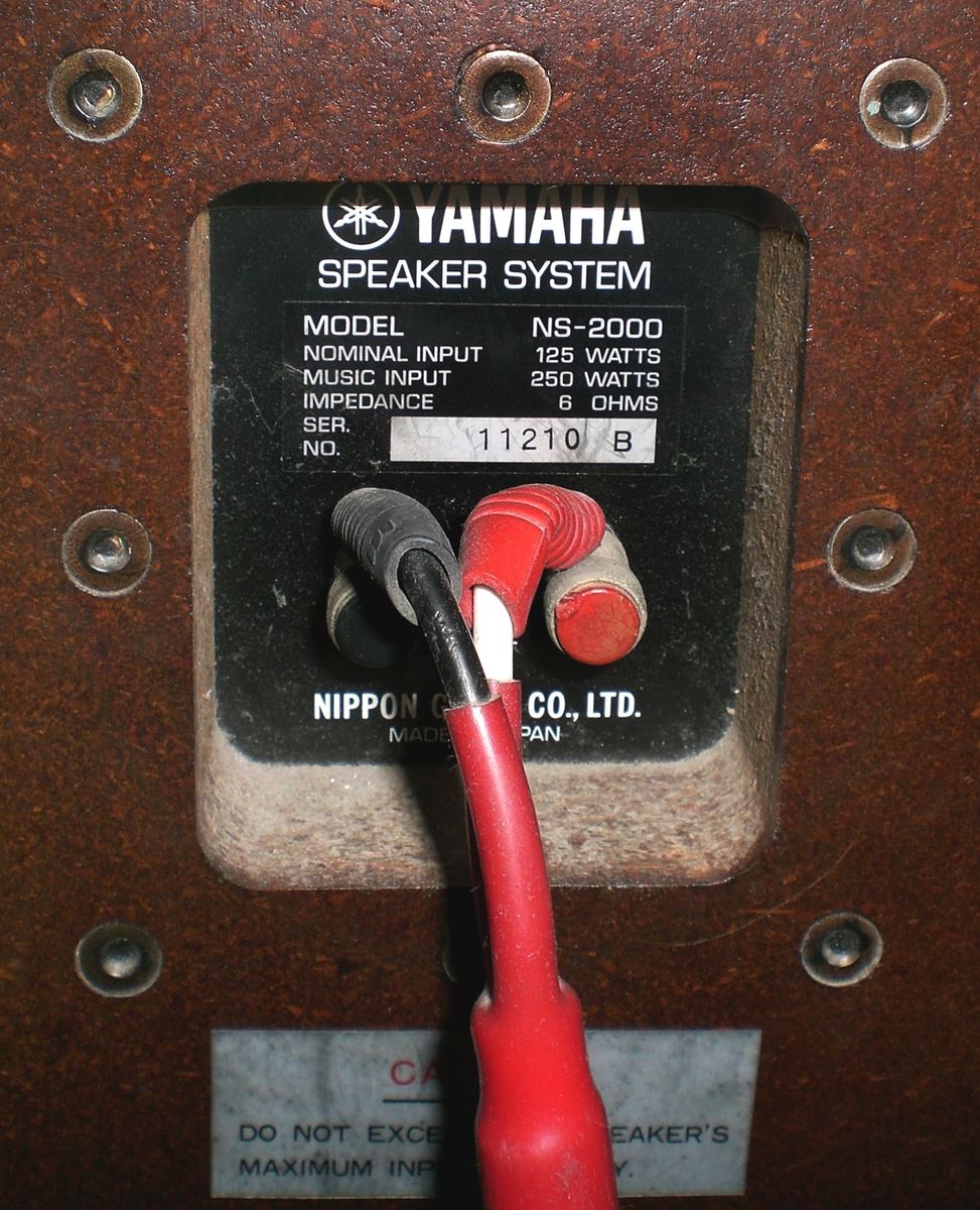Rear label of a Yamaha NS-2000 speaker listing model, impedance and power ratings above the terminals