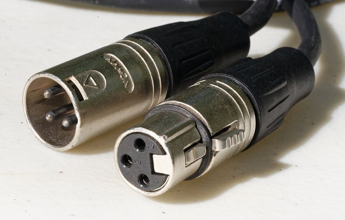Male and female XLR connectors side by side, showing three pins and three sockets