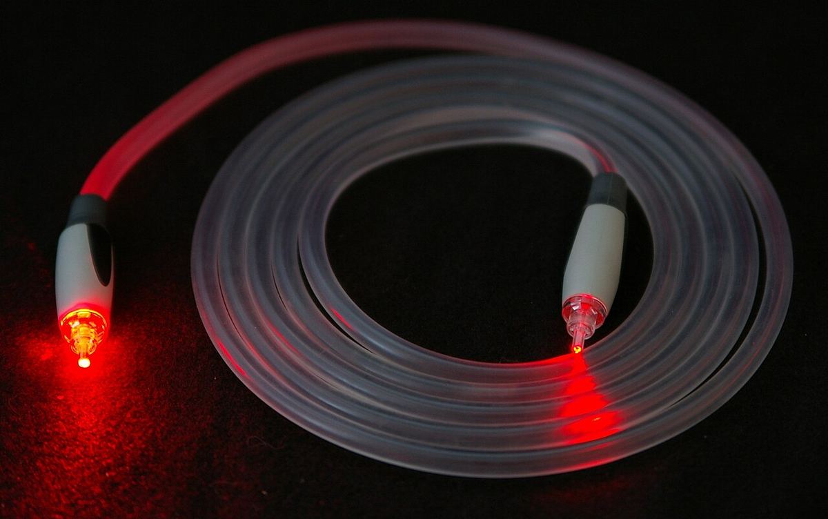 Clear TOSLINK optical cable glowing red at both connectors