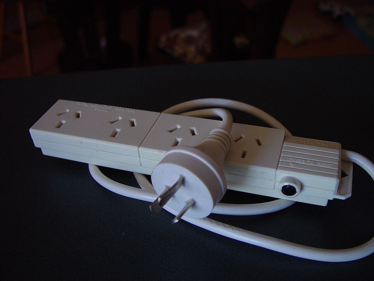 Four-way mains power board with several plugs connected