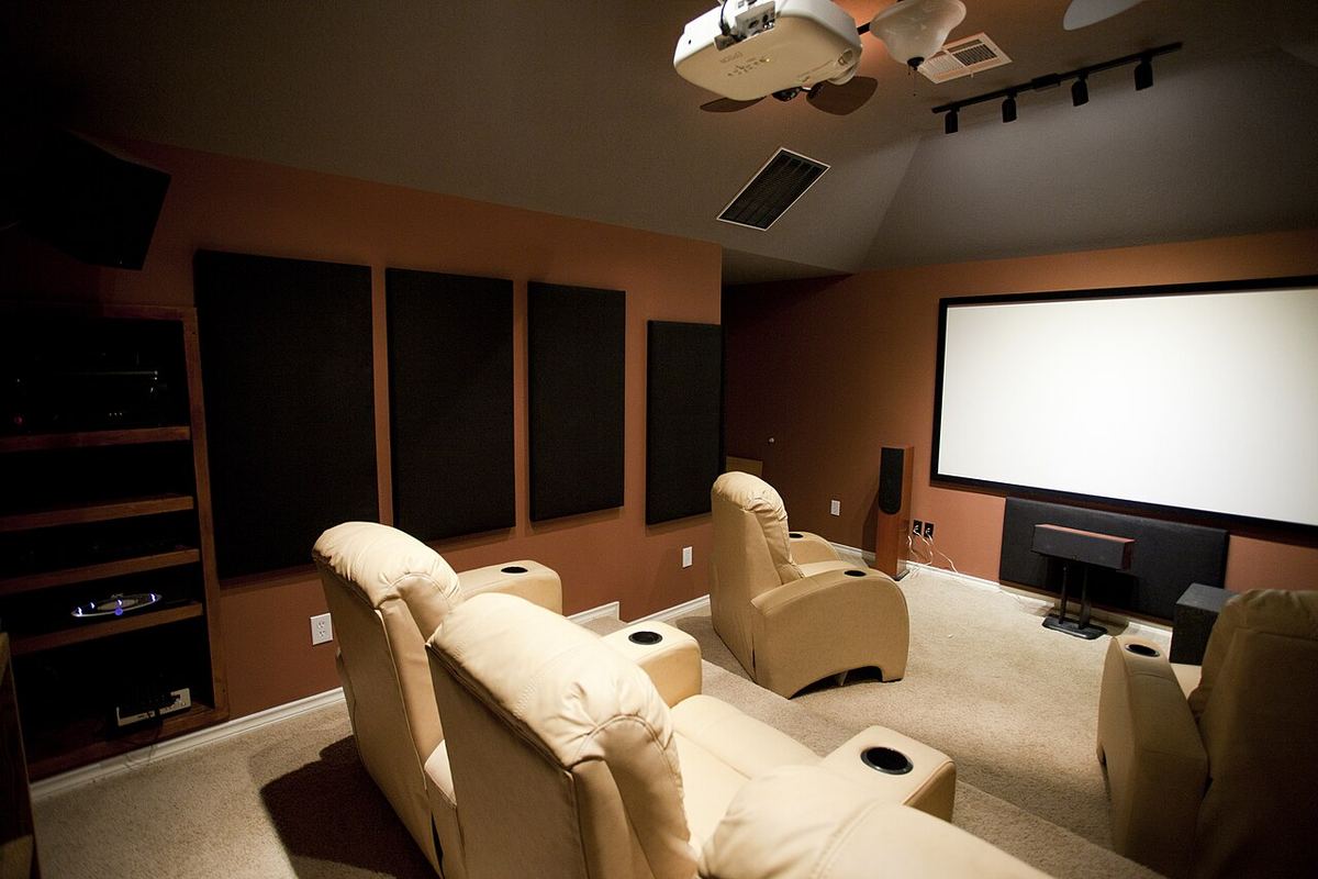 Dedicated home theater room with acoustic panels on the walls and tiered seating
