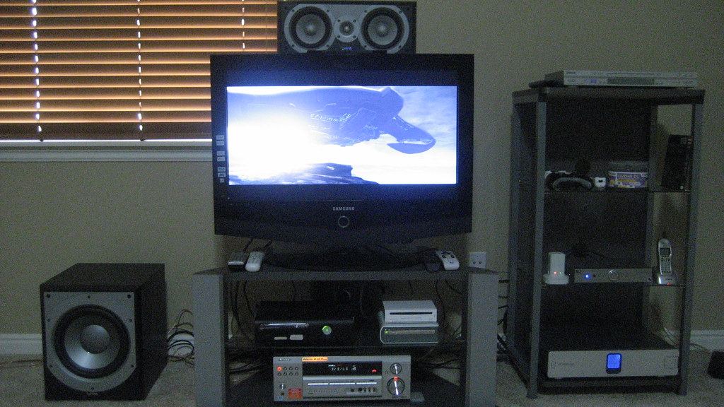 Home theater setup with a subwoofer on the floor beside the TV stand